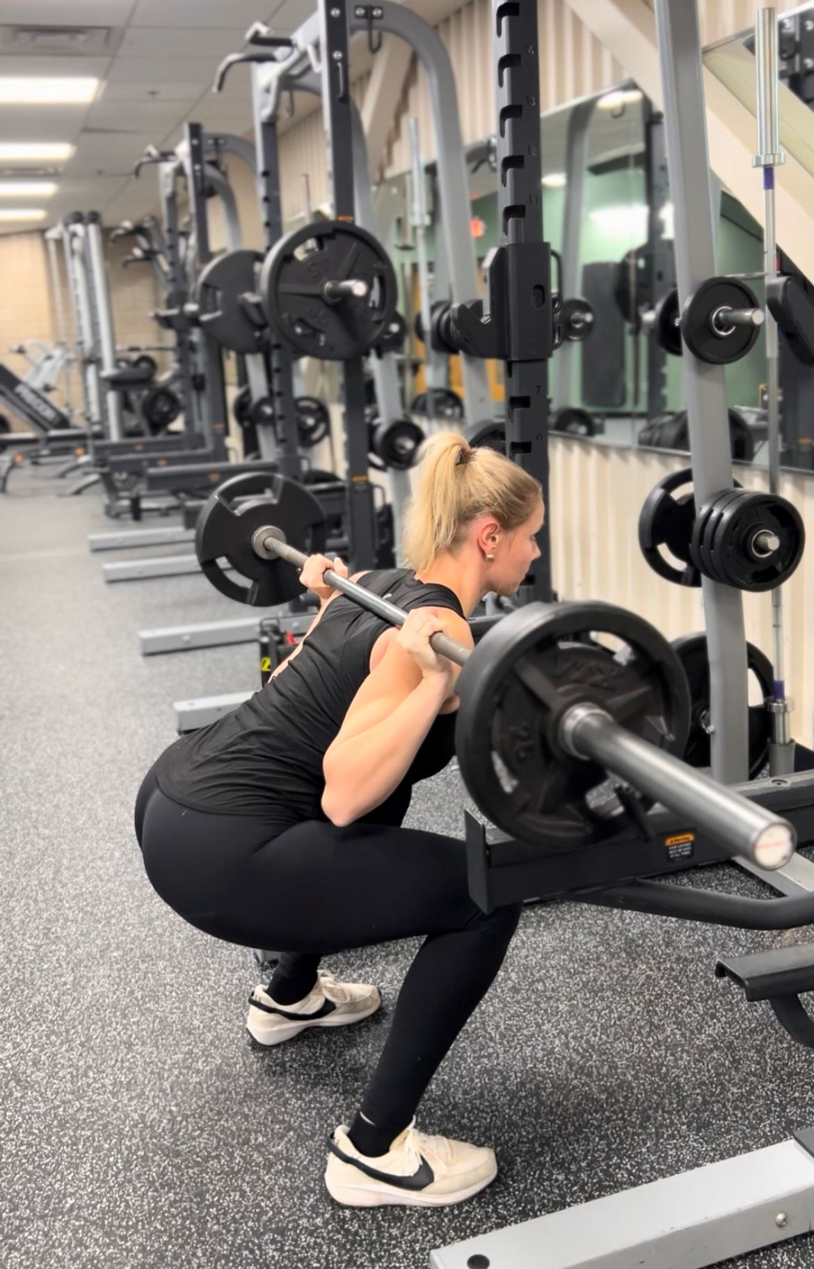 Woman using the squat rack in the fitness center