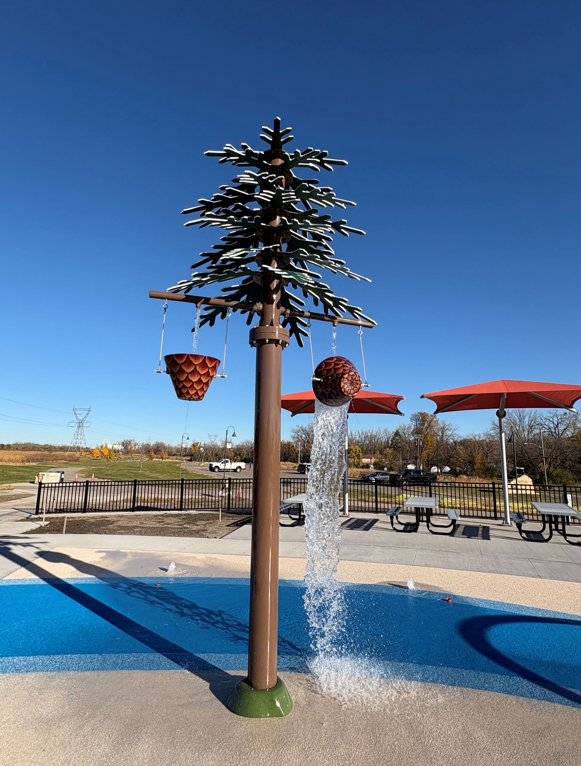 Tree with dumping buckets at the heritage village park splash pad