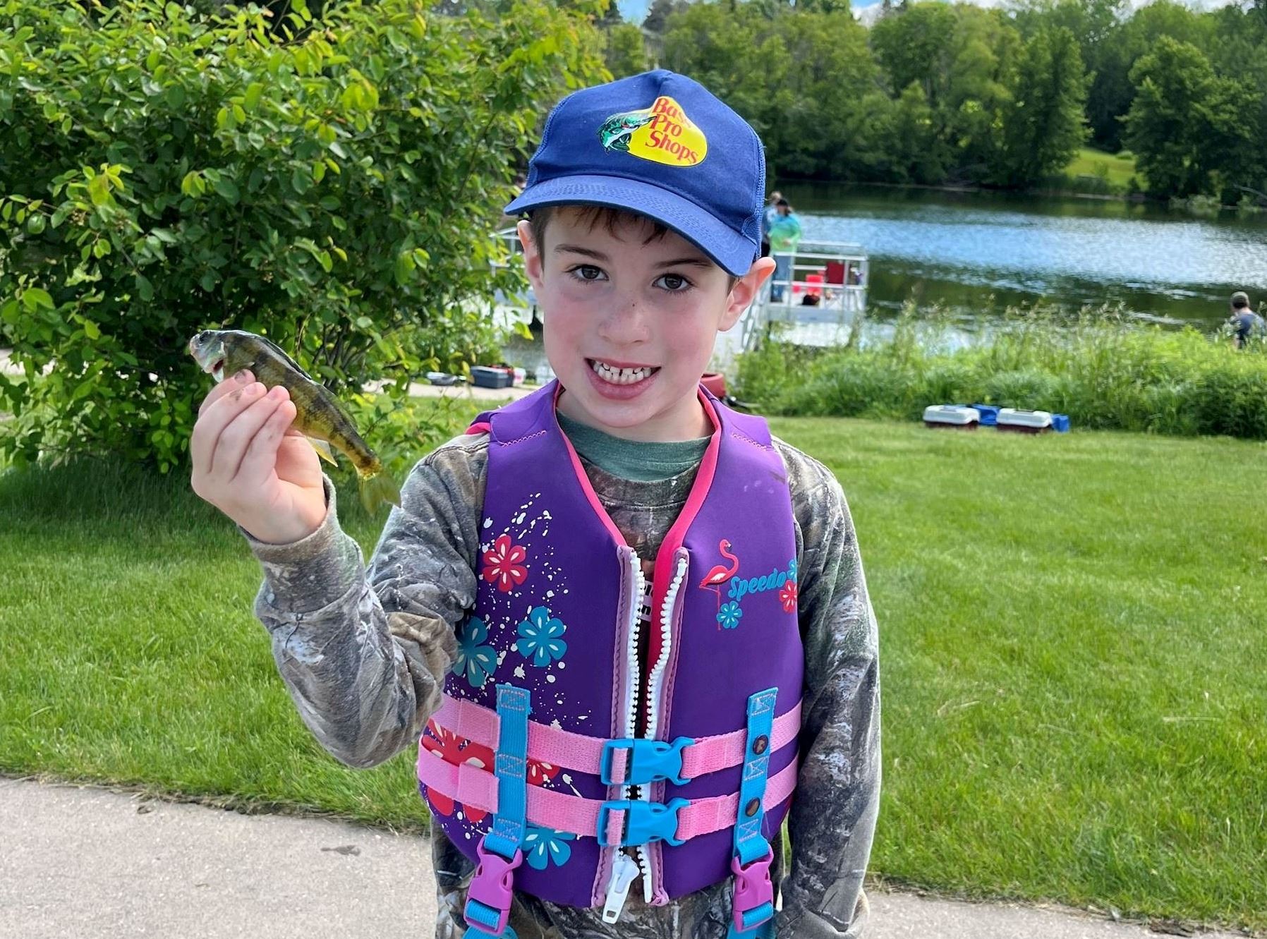 Child holding a small perch at the fishing derby